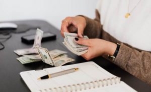 A person counting money, symbolizing ways to set up an emergency fund for your small business